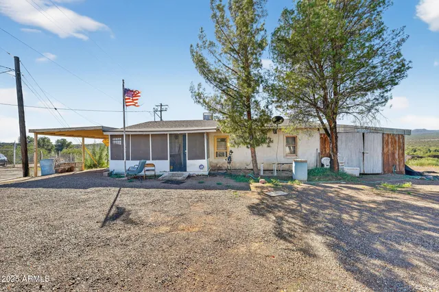 a view of a house with backyard and a tree