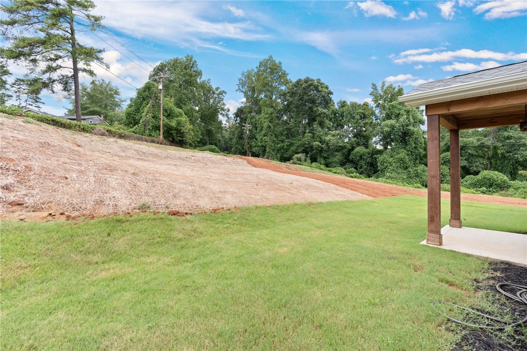 914 Smith Grove Road Easley, SC 29640 - Photo 28 of 37 A spacious backyard awaits, complete with a covered patio for outdoor enjoyment.