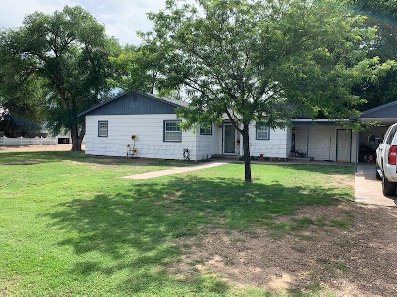 a view of a house with a backyard and a tree