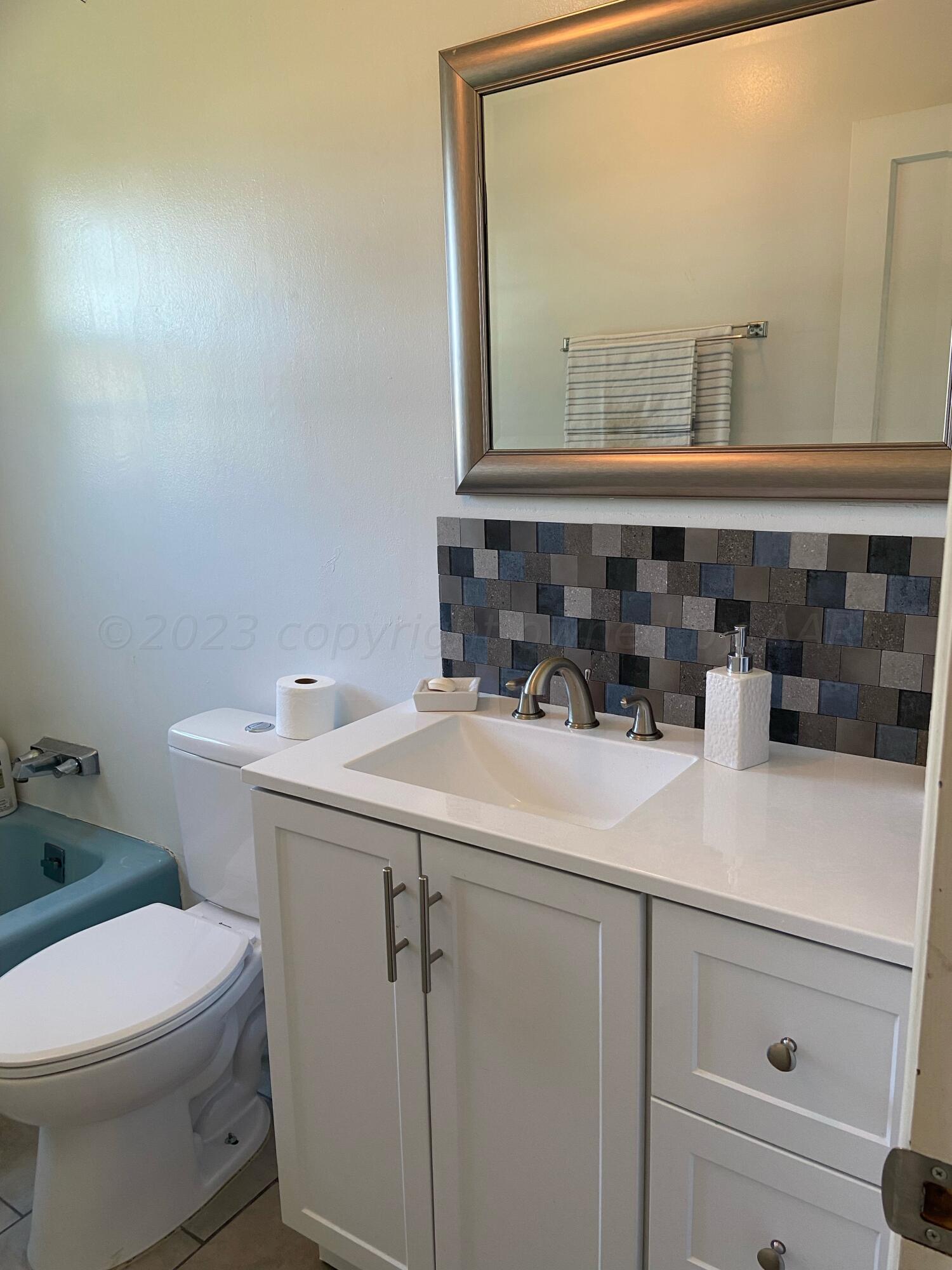 720 Santa Fe Avenue Channing, TX 79018 - Photo 15 of 23 a bathroom with a sink a toilet and mirror