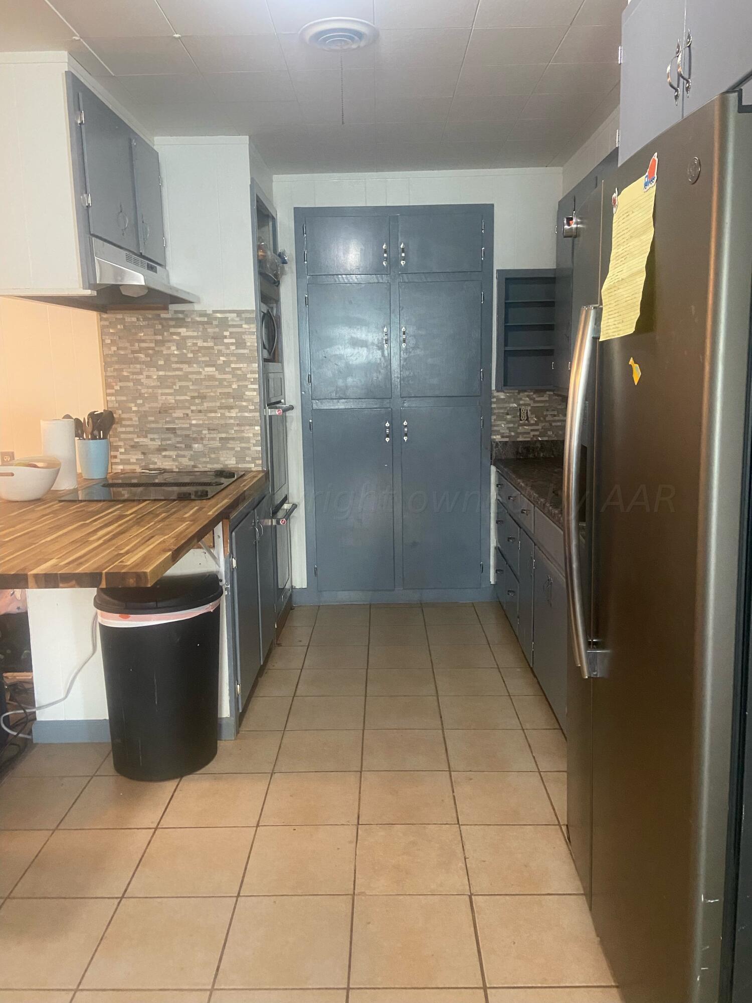 720 Santa Fe Avenue Channing, TX 79018 - Photo 6 of 23 a kitchen with stainless steel appliances granite countertop a refrigerator and a wooden cabinets