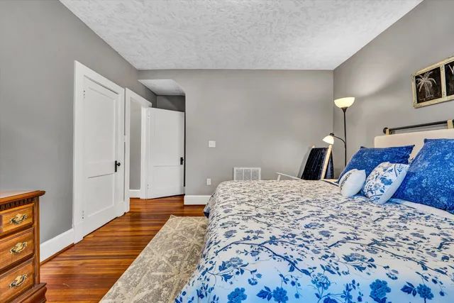 a bedroom with a large bed couch and a window