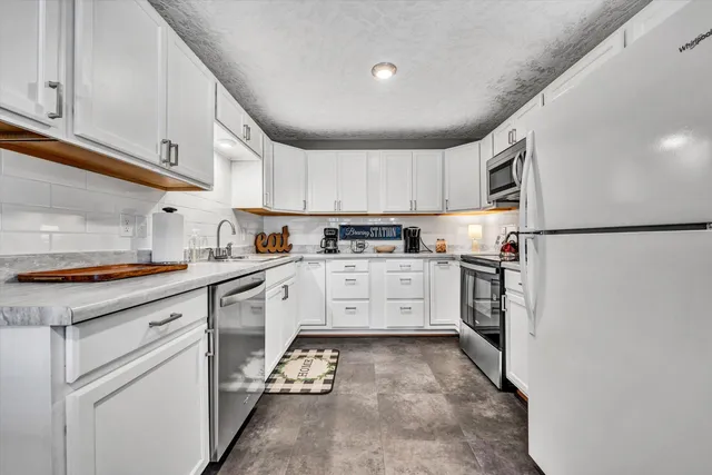 a kitchen with white cabinets stainless steel appliances and sink