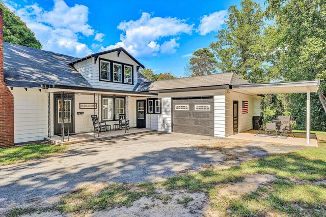 a view of a backyard with a garden and tree