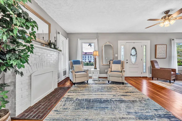 a living room with furniture floor to ceiling window and wooden floor