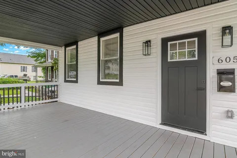a view of an house with deck and a floor to ceiling window