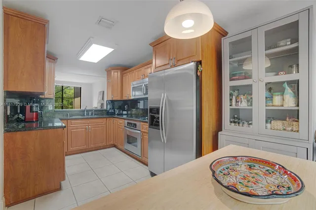 a kitchen with stainless steel appliances granite countertop a refrigerator and a stove