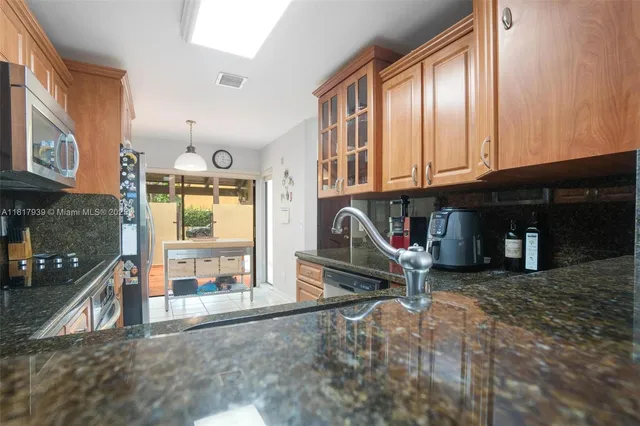 a kitchen with granite countertop cabinets stainless steel appliances and a sink
