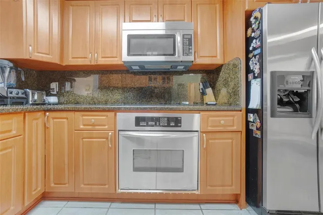 a kitchen with granite countertop cabinets stainless steel appliances and a sink