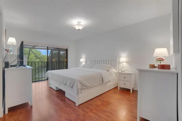 a spacious bedroom with a bed and a flat screen tv