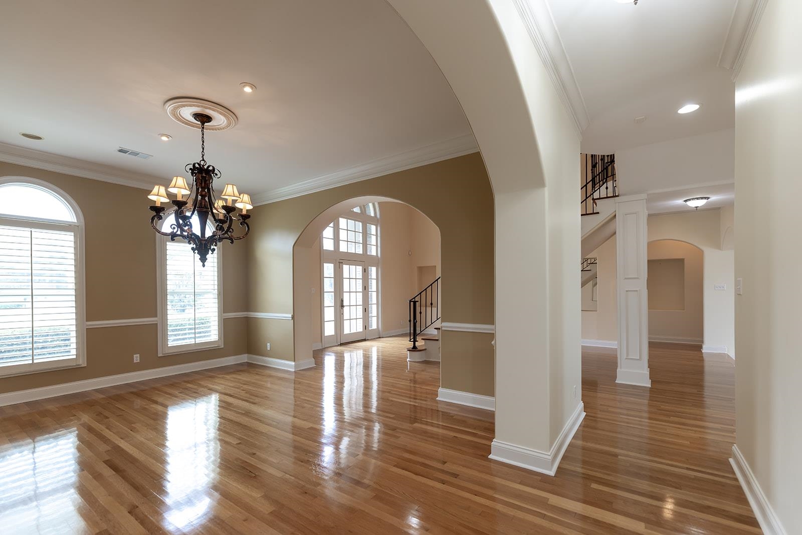 9390 Mayfield Road South Collierville, TN 38017 - Photo 10 of 40 Unfurnished room with stairs, arched walkways, crown molding, light wood-style floors, and a chandelier