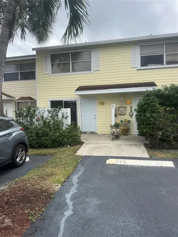 a view of a house with a yard and a car parked beside a road