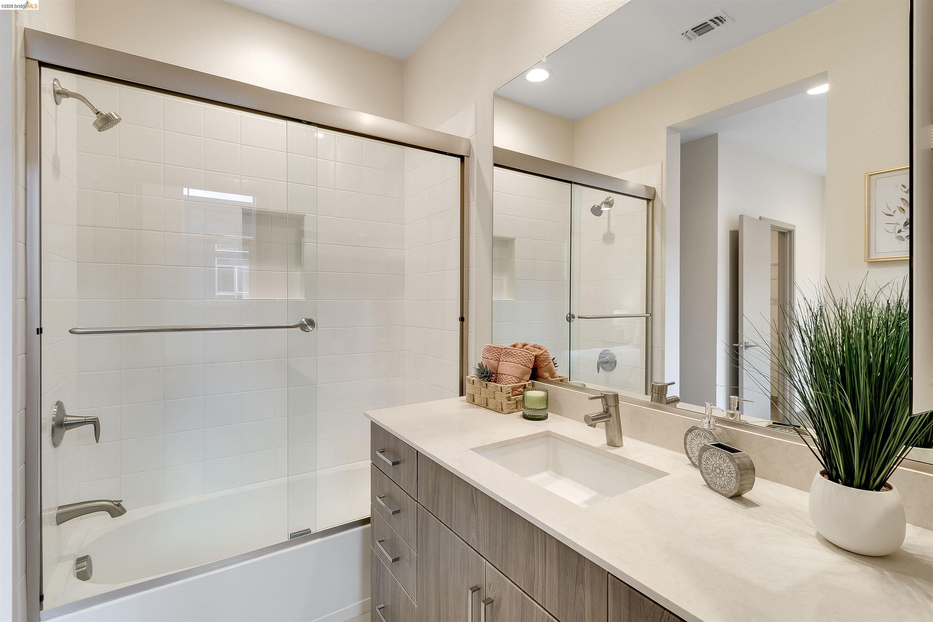 1357 Pullman Way Oakland, CA 94607 - Photo 30 of 37 Bathroom featuring a full vanity with an undermount sink, a quartz-finish countertop, and wood-finish cabinetry