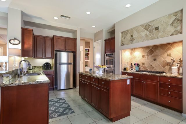 a kitchen with stainless steel appliances granite countertop a stove a sink dishwasher and a refrigerator