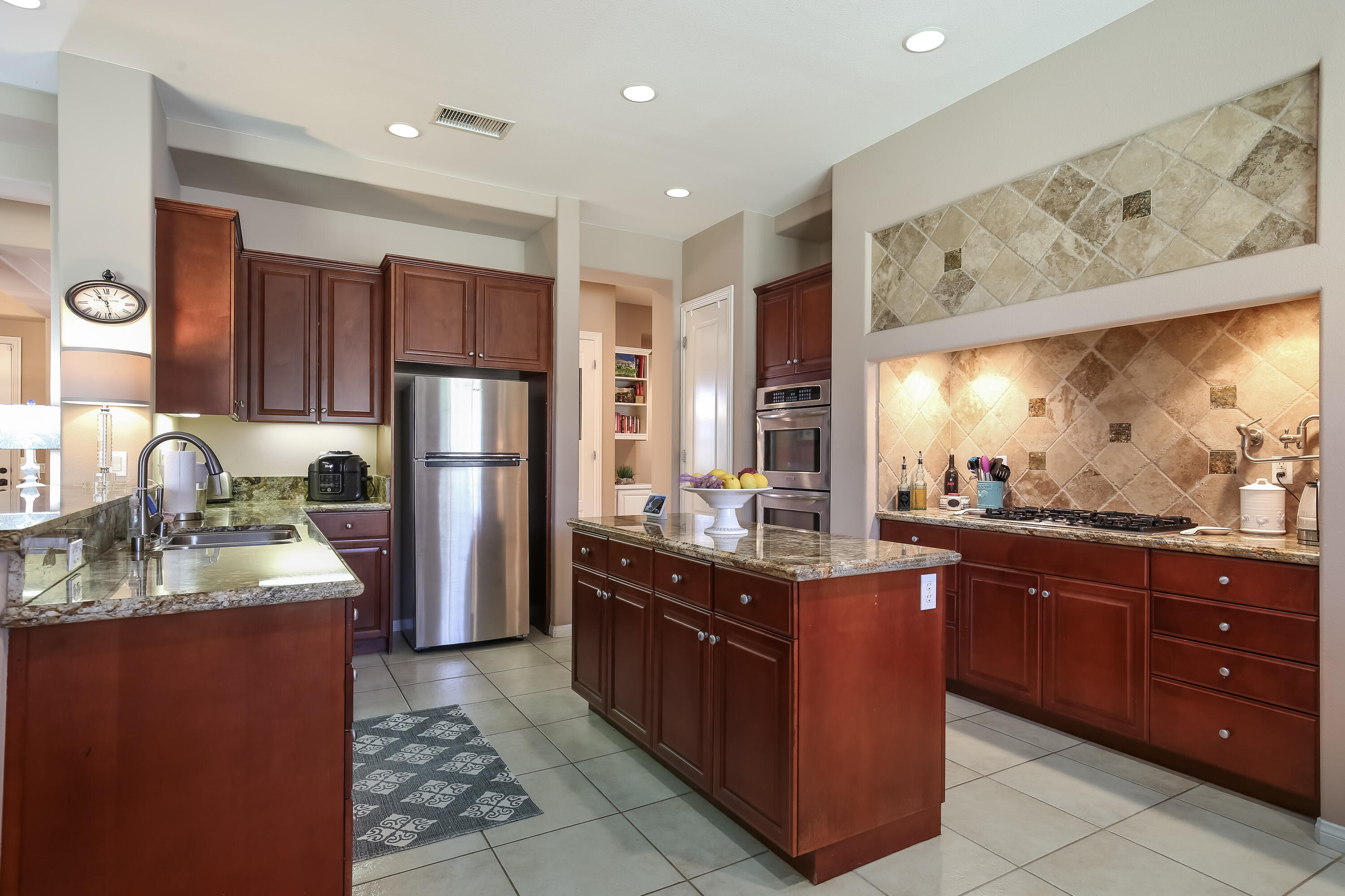 153 Bellini Way Palm Desert, CA 92211 - Photo 12 of 26 a kitchen with stainless steel appliances granite countertop a stove a sink dishwasher and a refrigerator
