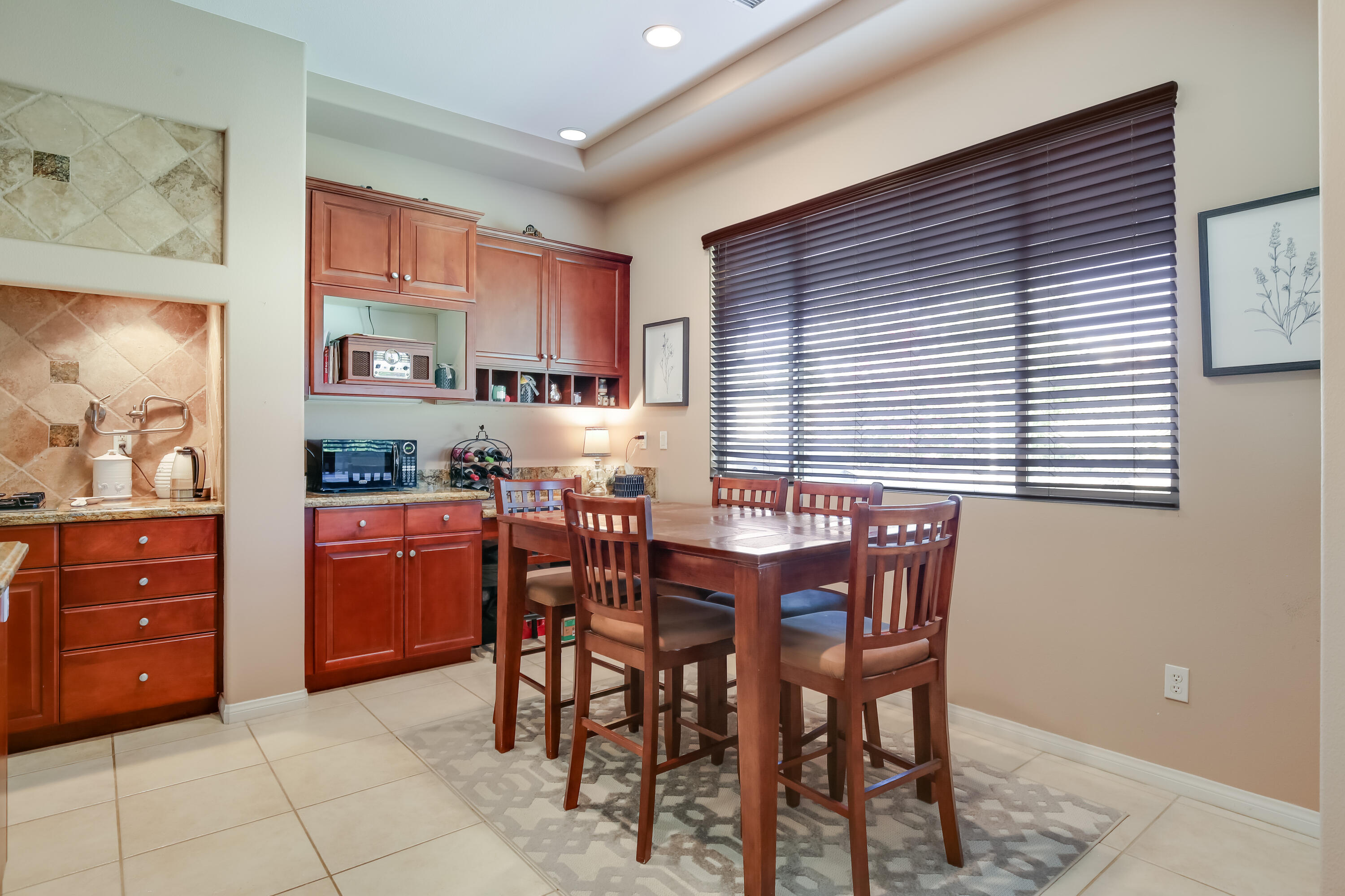 153 Bellini Way Palm Desert, CA 92211 - Photo 15 of 26 a kitchen with stainless steel appliances kitchen island granite countertop wooden cabinets dining table and chairs