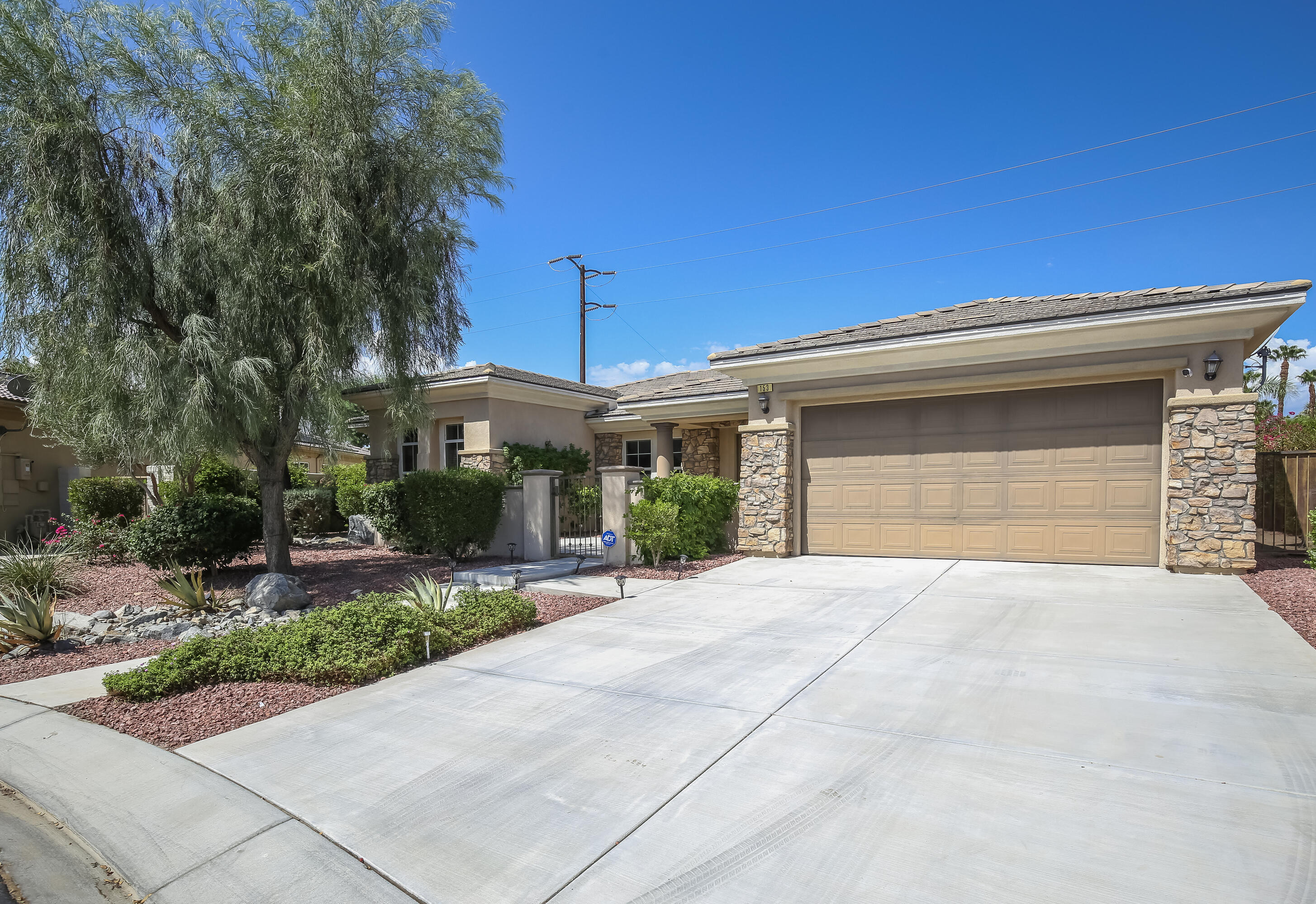153 Bellini Way Palm Desert, CA 92211 - Photo 5 of 26 a front view of a house with a yard and garage