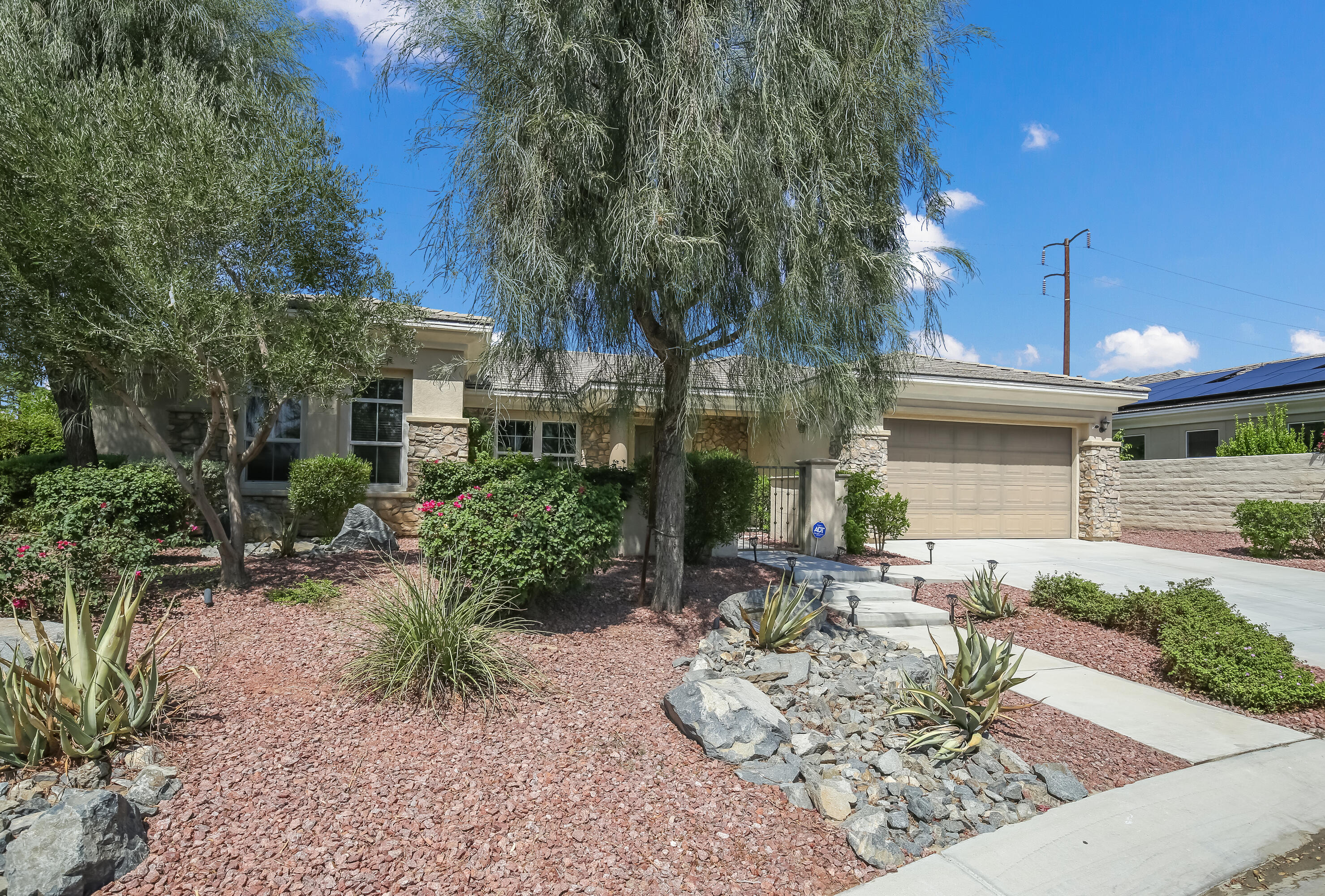 153 Bellini Way Palm Desert, CA 92211 - Photo 6 of 26 a view of a patio with table and chairs potted plants and large tree