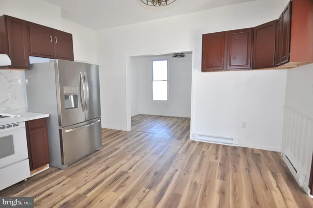 a kitchen with a refrigerator and wooden floor
