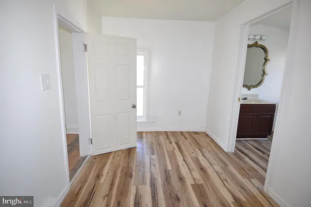 a view of a room with wooden floor and bathroom sink