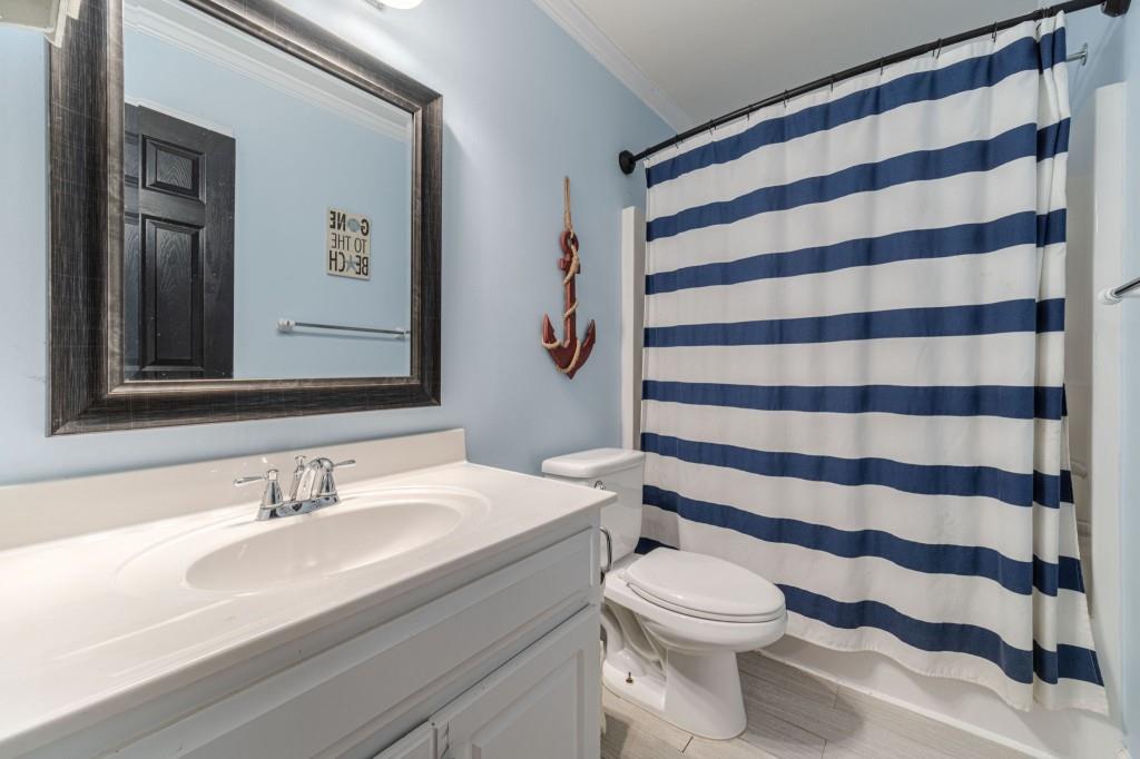 536 San Dra Way Monroe, GA 30656 - Photo 25 of 30 a bathroom with a sink a toilet a mirror and shower curtain
