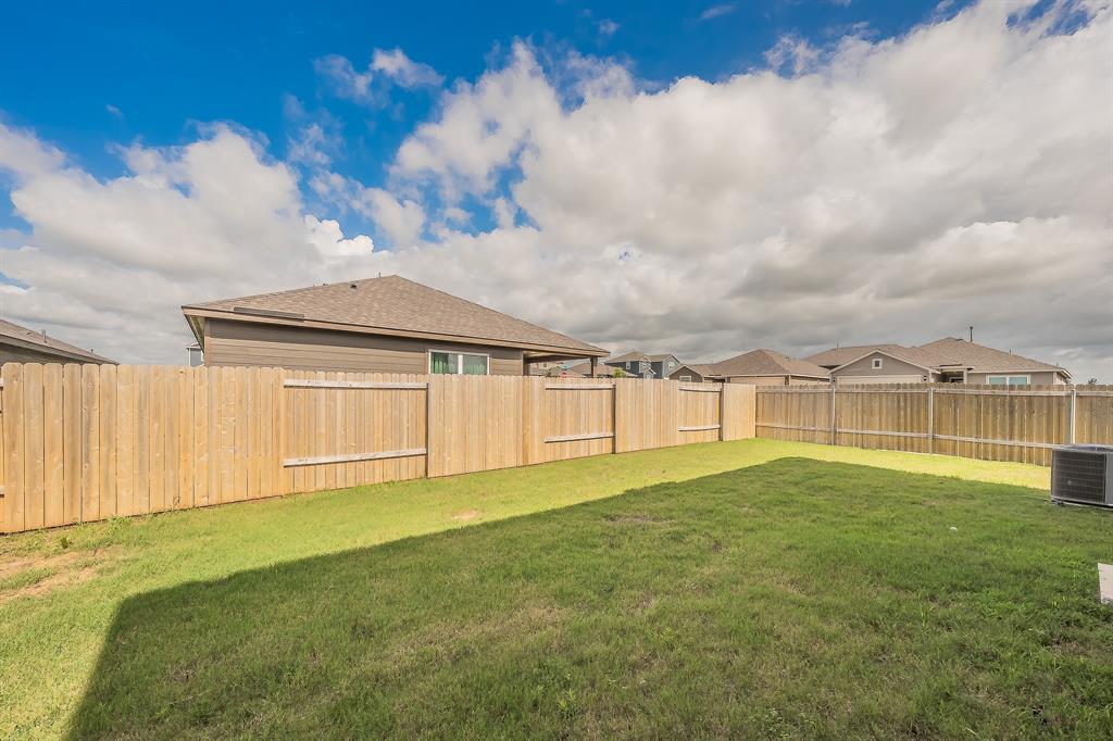 8125 White Sulphur Road Ponder, TX 76259 - Photo 33 of 38 Expansive backyard featuring a manicured lawn, complete wood privacy fencing, and an external HVAC unit