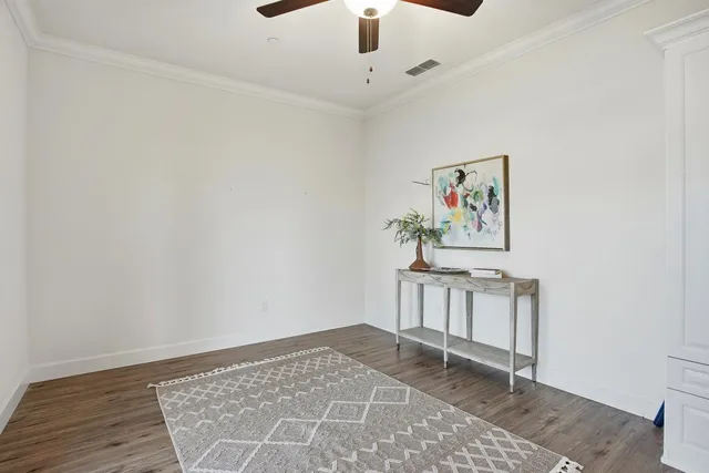 a view of a hallway with wooden floor and workspace