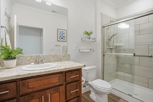a bathroom with a granite countertop sink toilet and shower