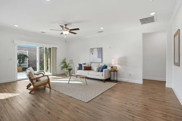 a living room with furniture and a wooden floor