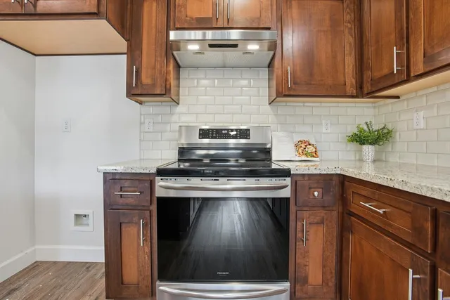 a kitchen with granite countertop wood cabinets and stainless steel appliances
