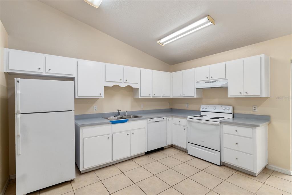 4329 Northwest 155th Street Reddick, FL 32686 - Photo 24 of 52 a kitchen with white cabinets sink and a refrigerator