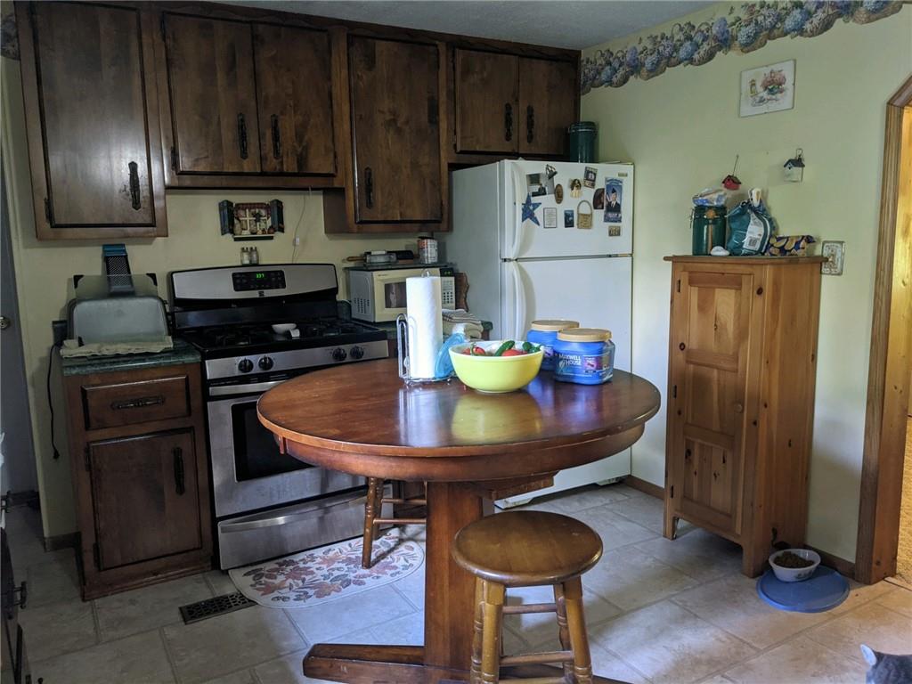 228 Summer Road Rural Valley, PA 16249 - Photo 8 of 25 a kitchen with granite countertop cabinets a refrigerator and a stove top oven