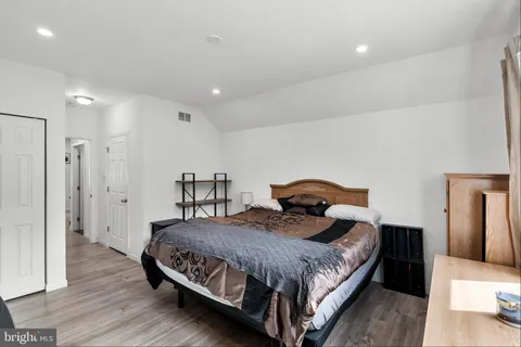 a bedroom with a bed and wooden floor