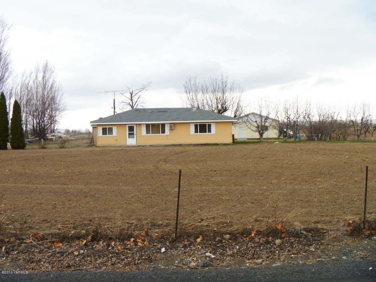 166902 West Johnson Road Prosser, WA 99350 - Photo 29 of 29 a view of a white house next to a yard and lake view
