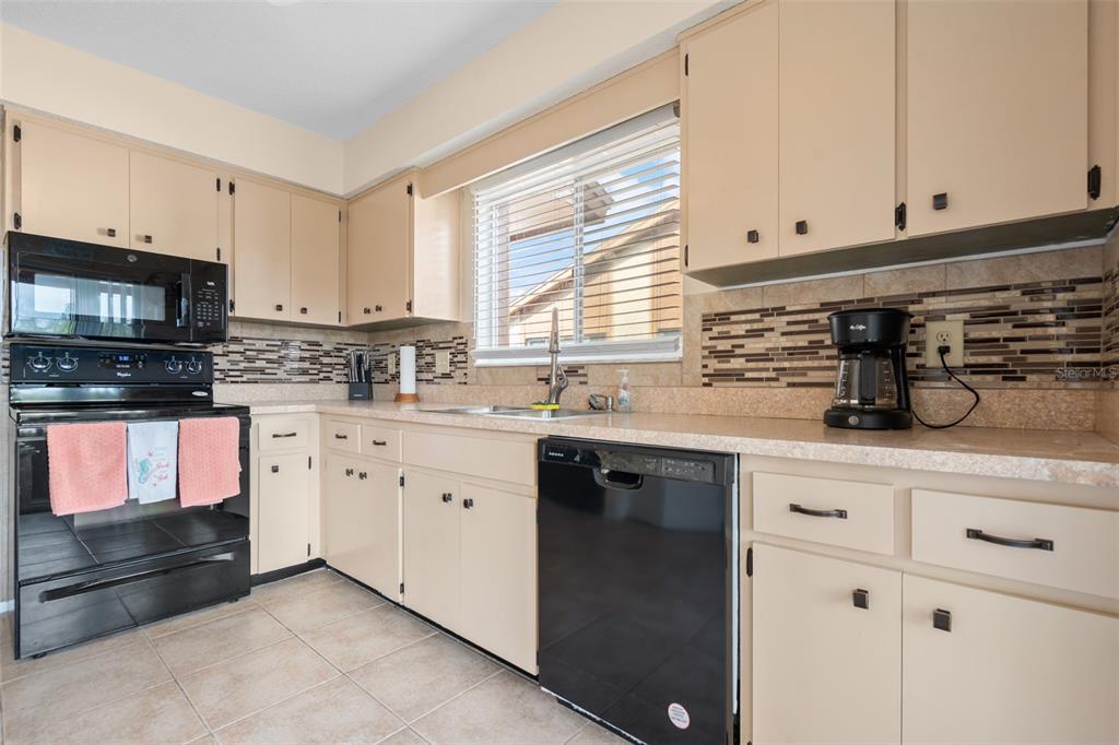 4036 Davit Drive New Port Richey, FL 34652 - Photo 24 of 64 a kitchen with granite countertop white cabinets stainless steel appliances a sink and a window