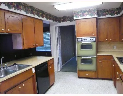 a kitchen with stainless steel appliances granite countertop a refrigerator a sink and wooden cabinets