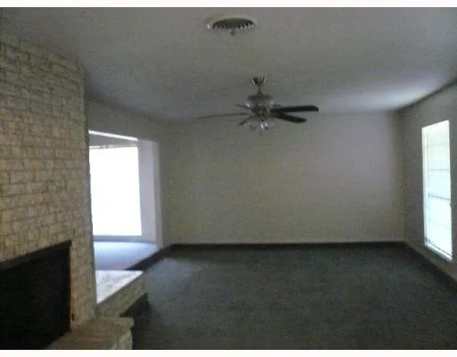 a view of a livingroom with a ceiling fan and window