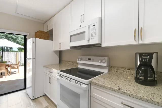 a kitchen with white cabinets and white appliances