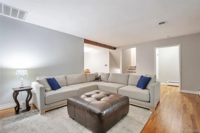 a living room with furniture and a wooden floor