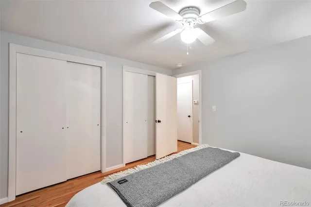 a bedroom with a bed and a chandelier fan