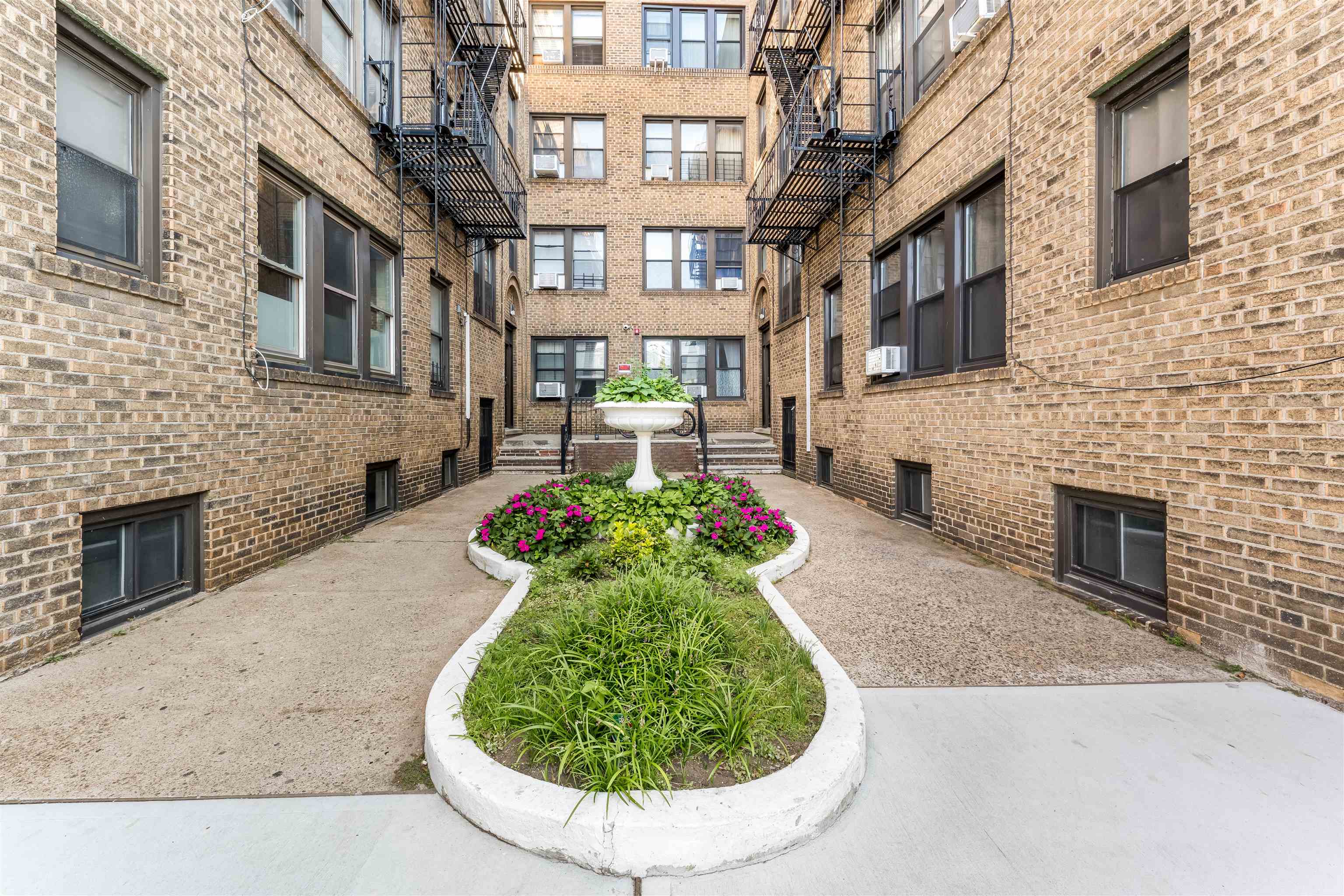 150 37th Street, Unit D4 Union City, NJ 07087 - Photo 20 of 22 a front view of a brick house with a yard