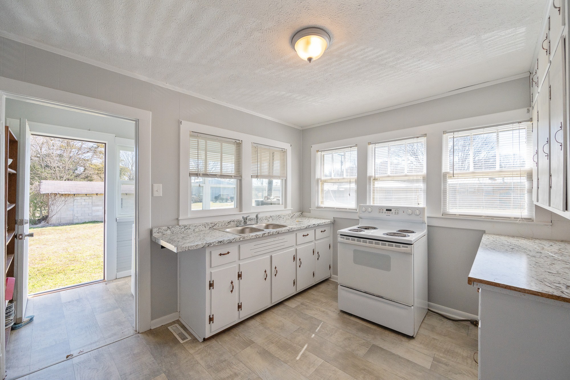 1213 Perryville Road Parsons, TN 38363 - Photo 14 of 32 a kitchen with a stove a sink and a refrigerator