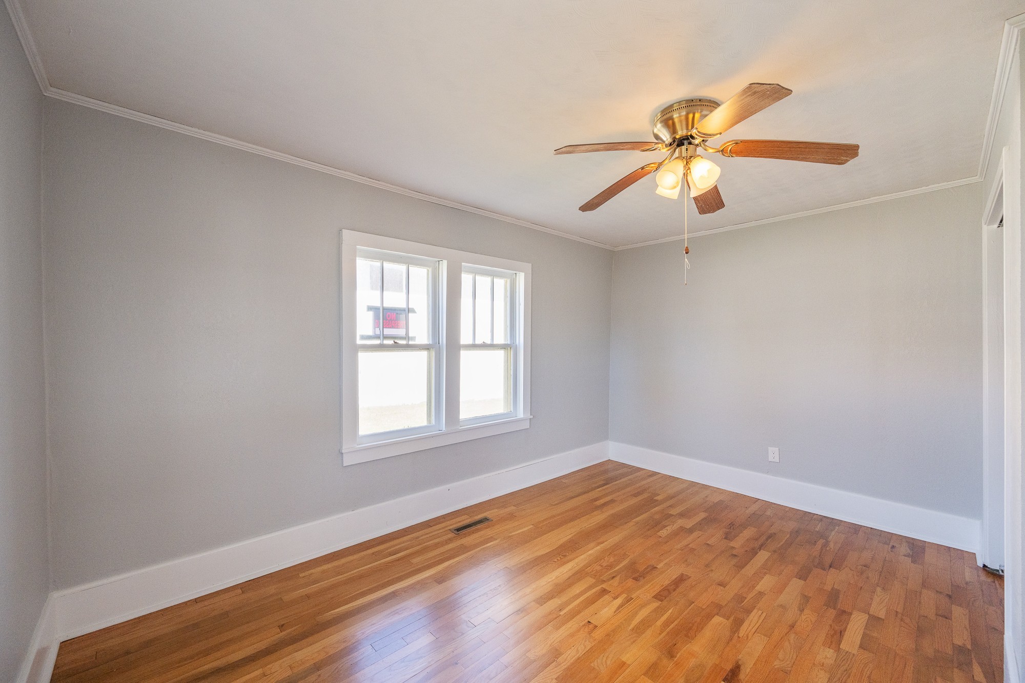1213 Perryville Road Parsons, TN 38363 - Photo 18 of 32 an empty room with wooden floor fan and windows