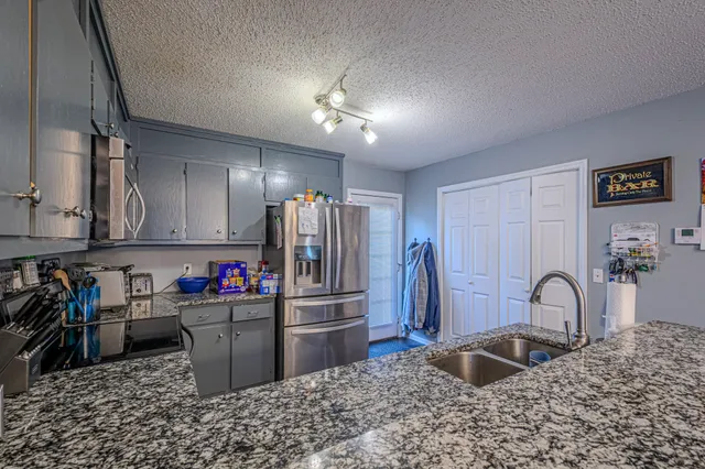 a kitchen with stainless steel appliances a sink stove and refrigerator