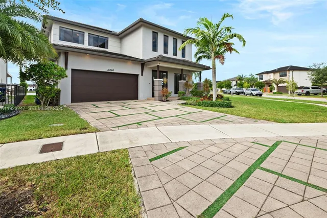 a front view of a house with a yard and potted plants