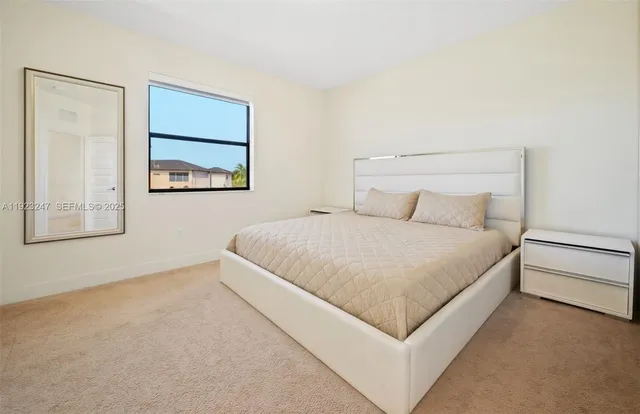 a large bed sitting in a bedroom next to a window