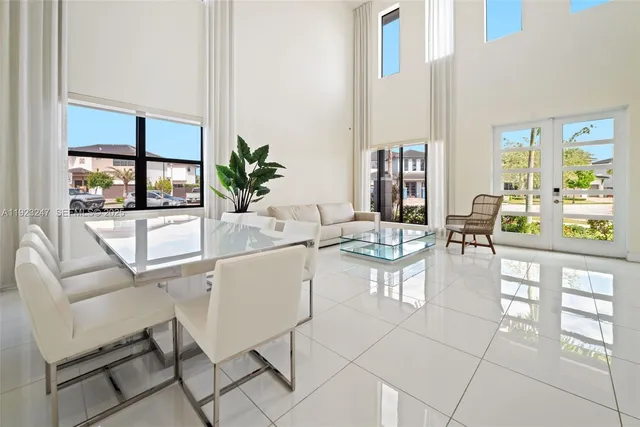a living room with furniture a large window and potted plants