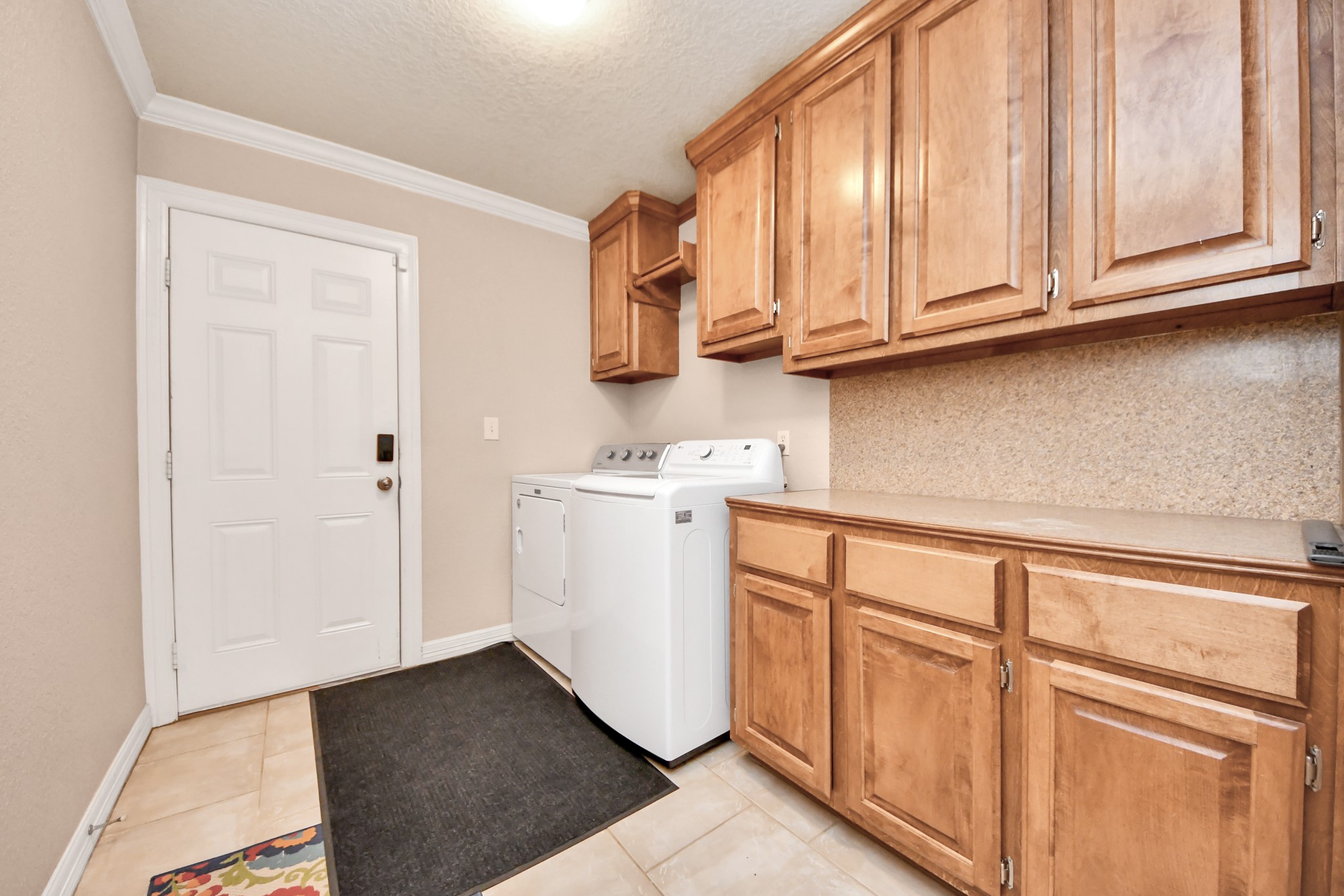 1102 West Point Drive Rosharon, TX 77583 - Photo 28 of 39 Spacious laundry room with ample wooden cabinetry, washer and dryer, and convenient access to the outdoors.