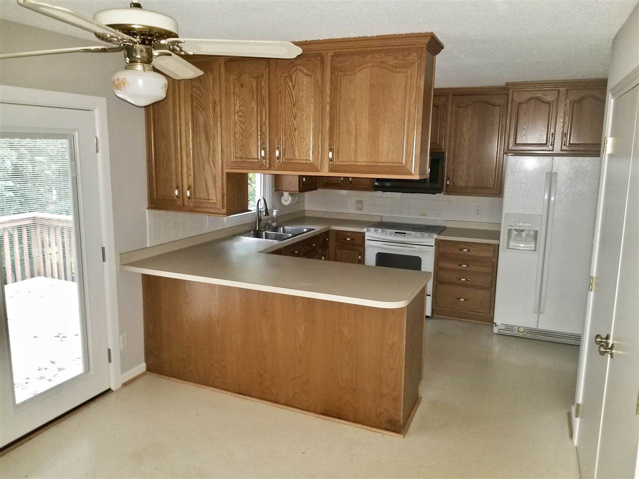 6420 Rockrest Court Raleigh, NC 27612 - Photo 4 of 22 Upper level eat-in kitchen w/ sliding door access to rear deck - appliances convey