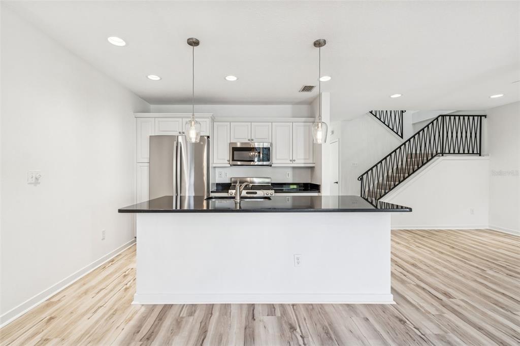 1685 Laurel Street, Unit 3 Sarasota, FL 34236 - Photo 8 of 54 a large kitchen with stainless steel appliances kitchen island wooden floors and white cabinets